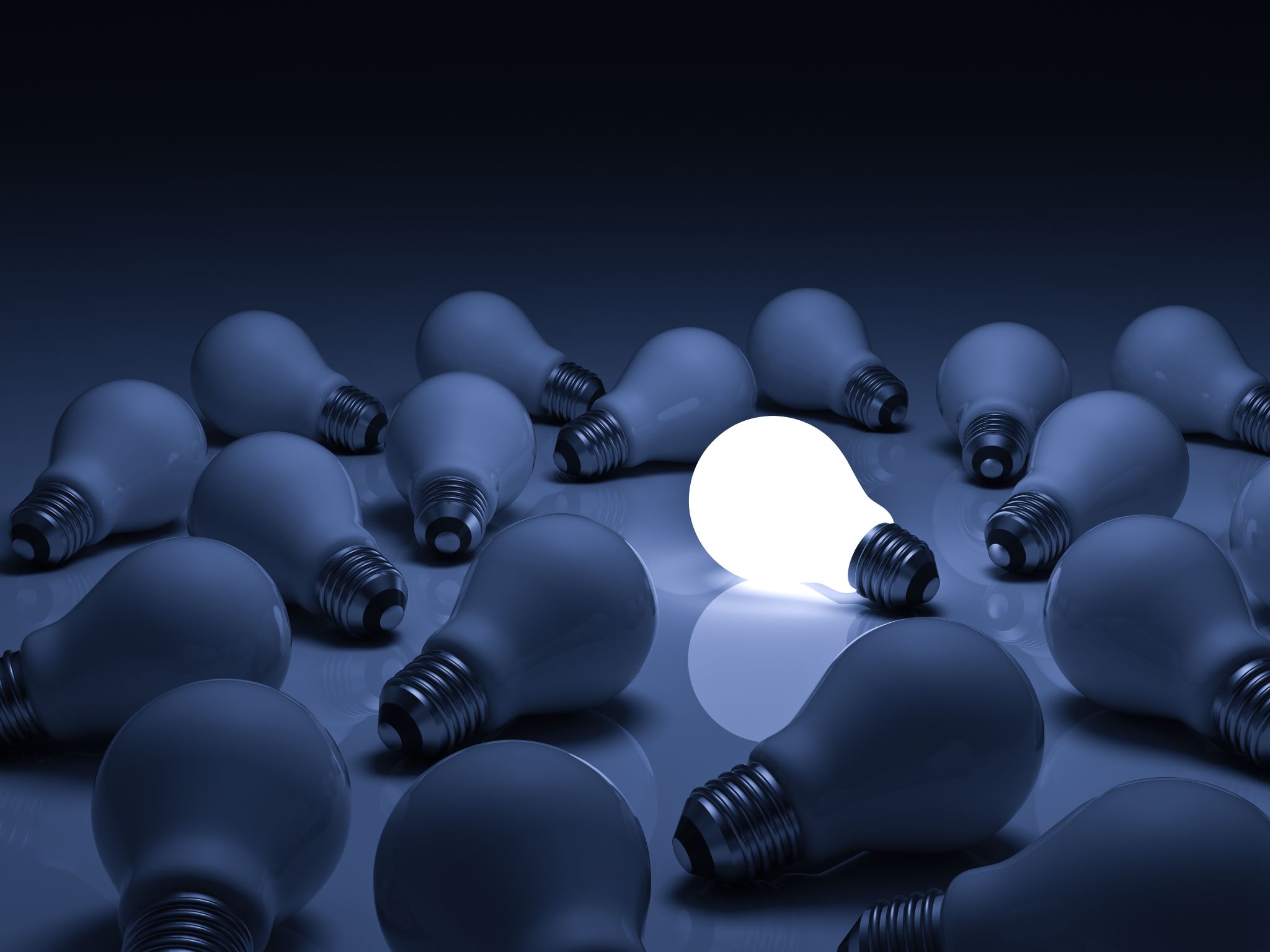 Glowing light bulb among unlit bulbs