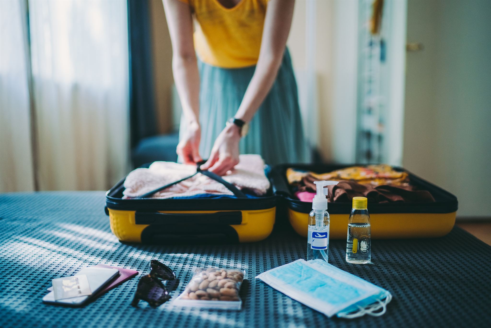 Person-packing-yellow-suitcase